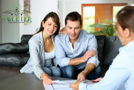 Couple signing papers with agent