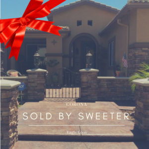 Front view of home with red bow and caption "Sold by Sweeter"