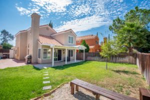 Back yard view featuring patio and landscaped yard