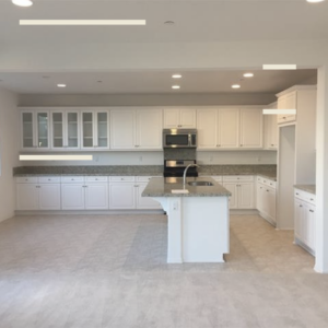 View of new kitchen with white cabinets and grey color scheme to accent stainless steel appliances.