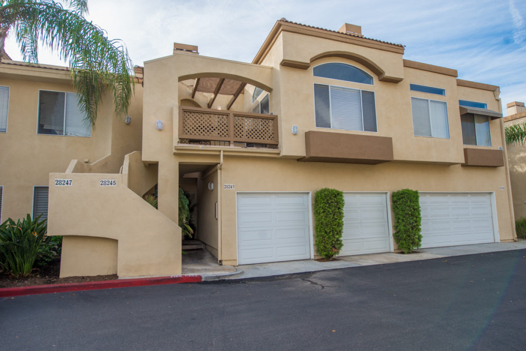 Front view of top level condo showing garage door and patio above